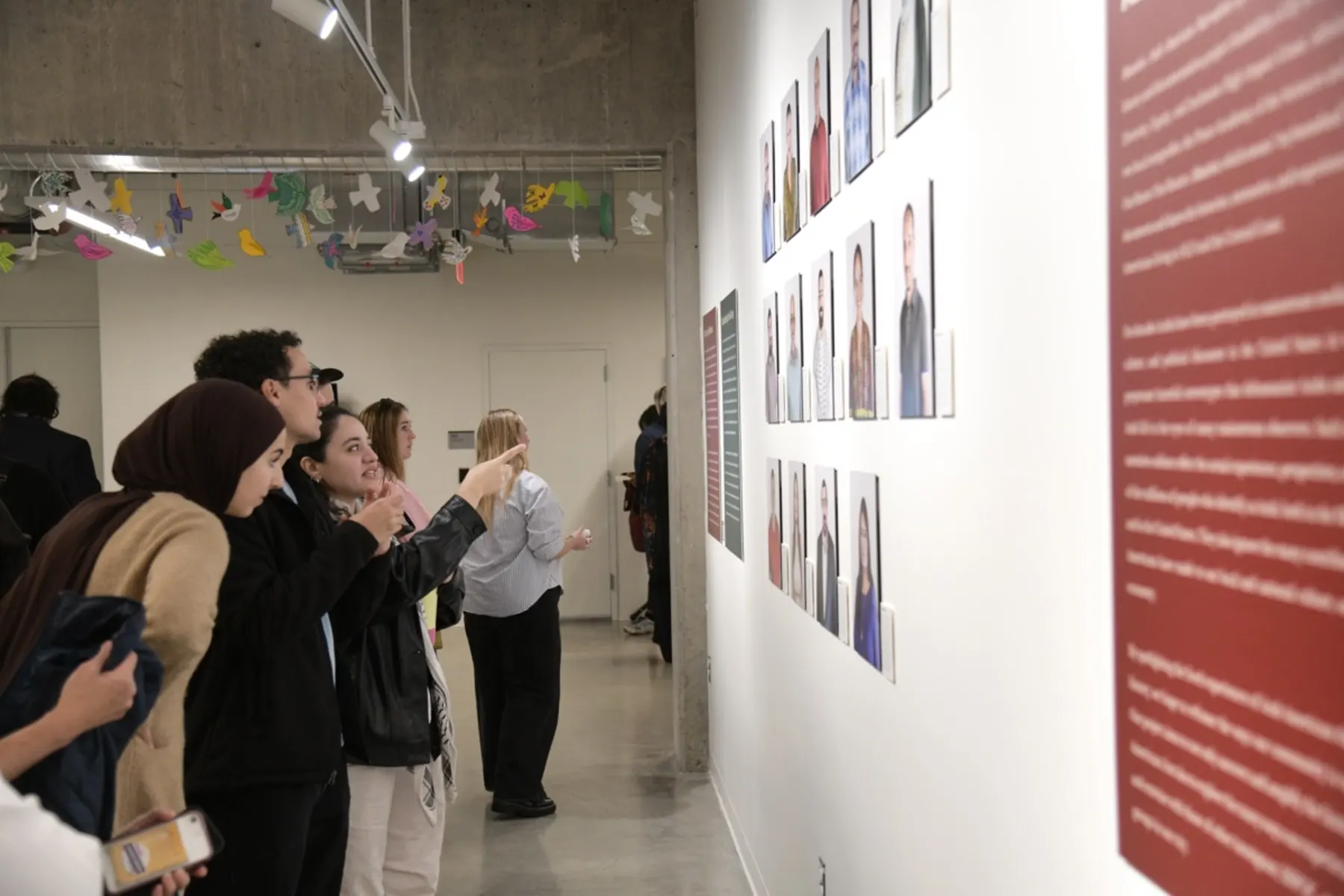 Visitors photographing portraits at the Mawtini exhibition